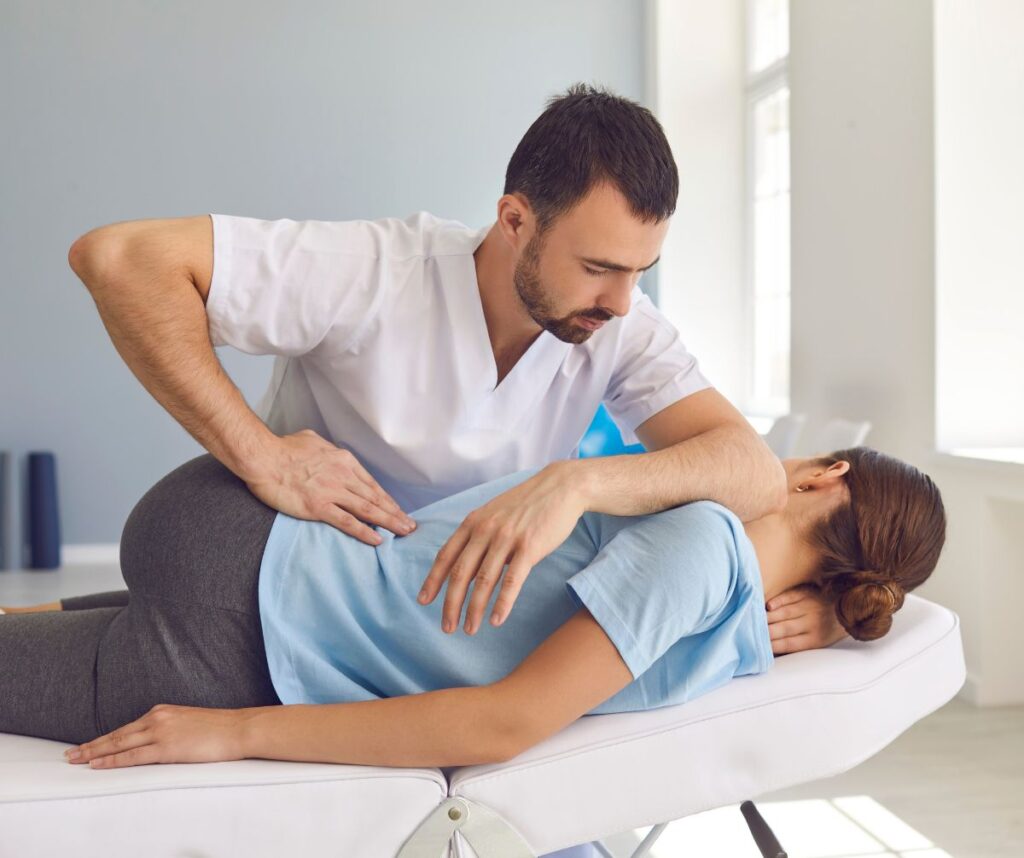 Chiropractor Fixing a Woman with Back Pain in a Clinic.